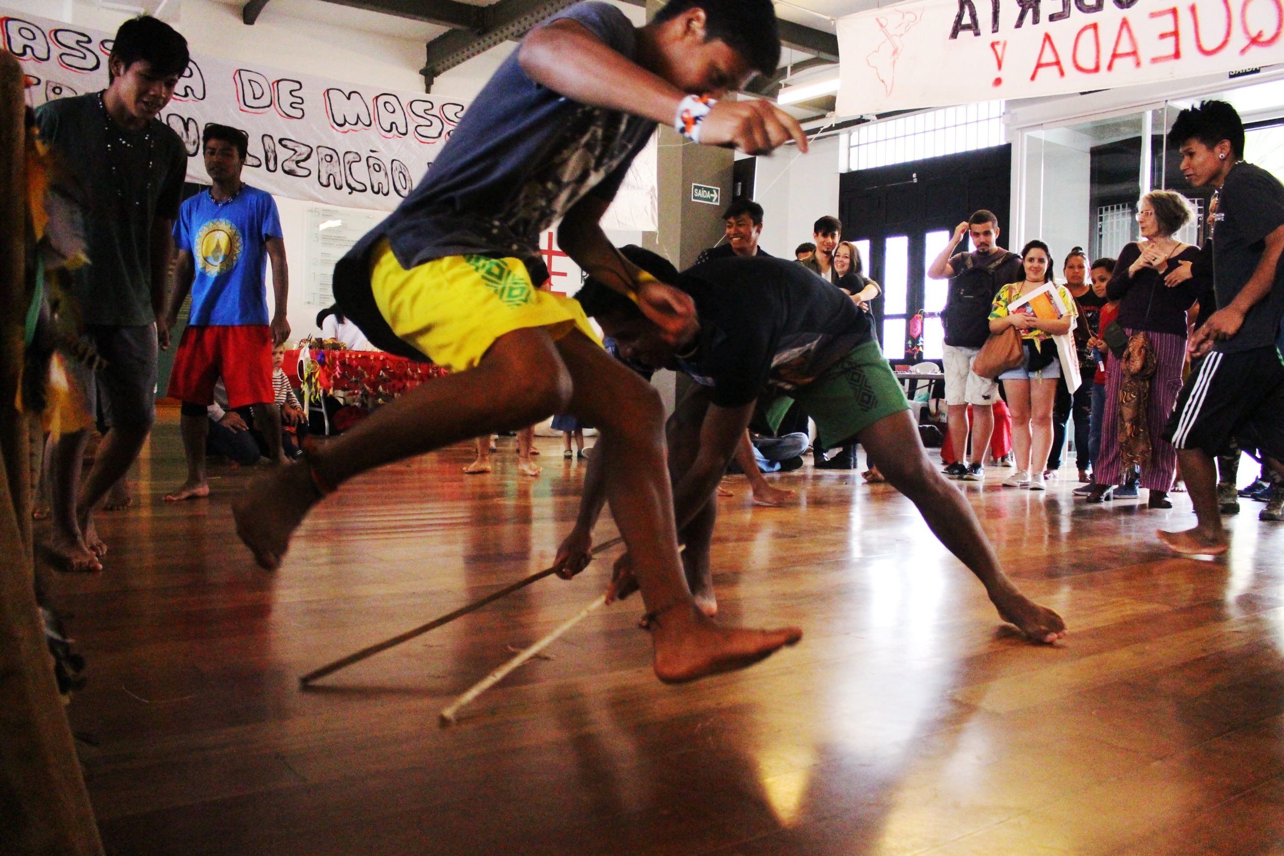 Jovens participando de um jogo durante a exposição: Ser essa terra: São Paulo cidade indígena que aconteceu no Memorial da Resistência de São Paulo, tendo como recorte o território da cidade de São Paulo e a luta de povos originários e migrantes pela própria existência, pela garantia de seus direitos, pelo direito à terra e aos seus modos-de-vida e modos-de-ser. A exposição mostrou as tentativas de apagamento dos indígenas na cidade e as violências a que eram submetidos, inclusive no período da Ditadura Militar (1964 – 1985).